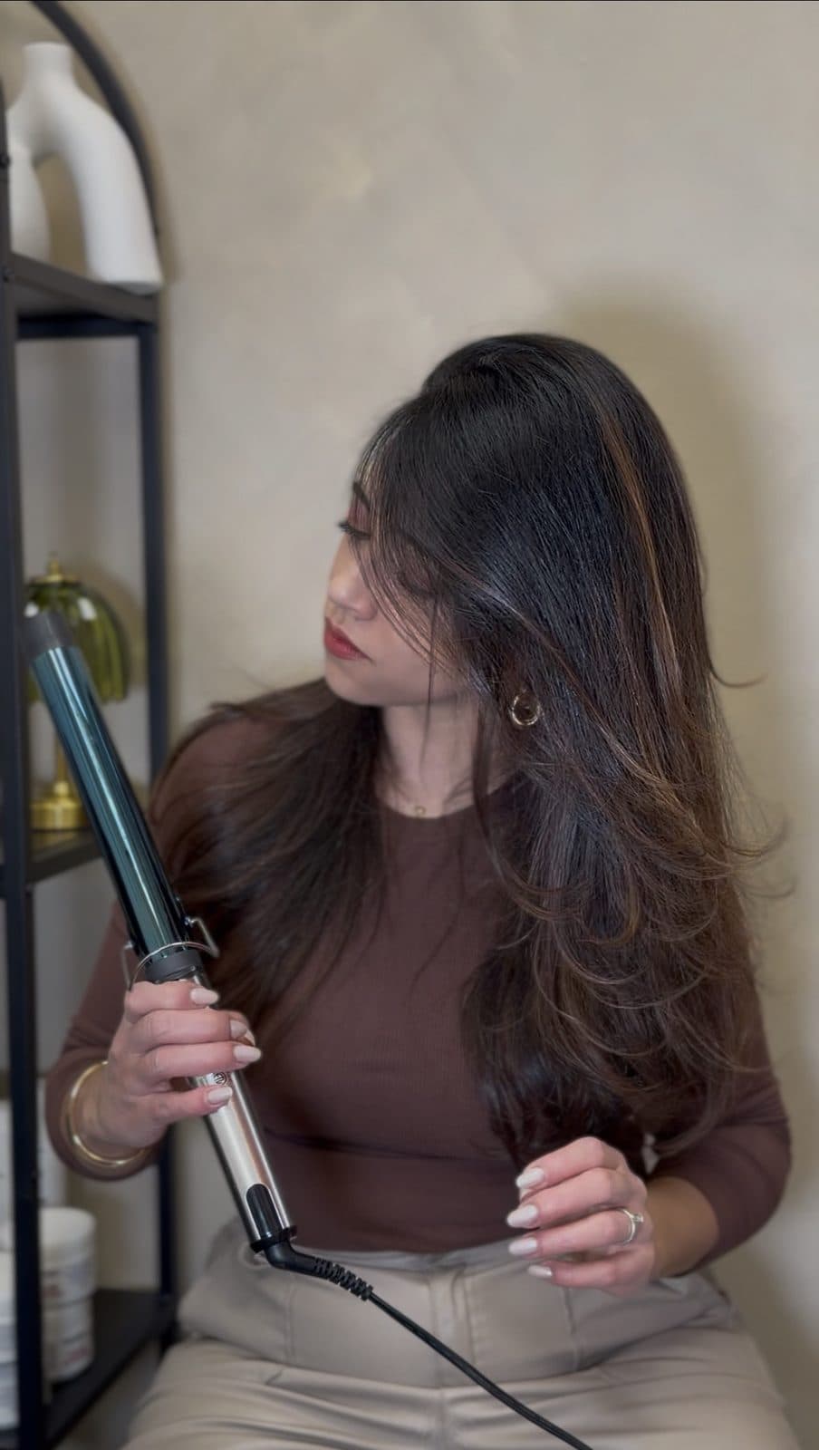 Amanda styling long hair with a curling iron in the salon